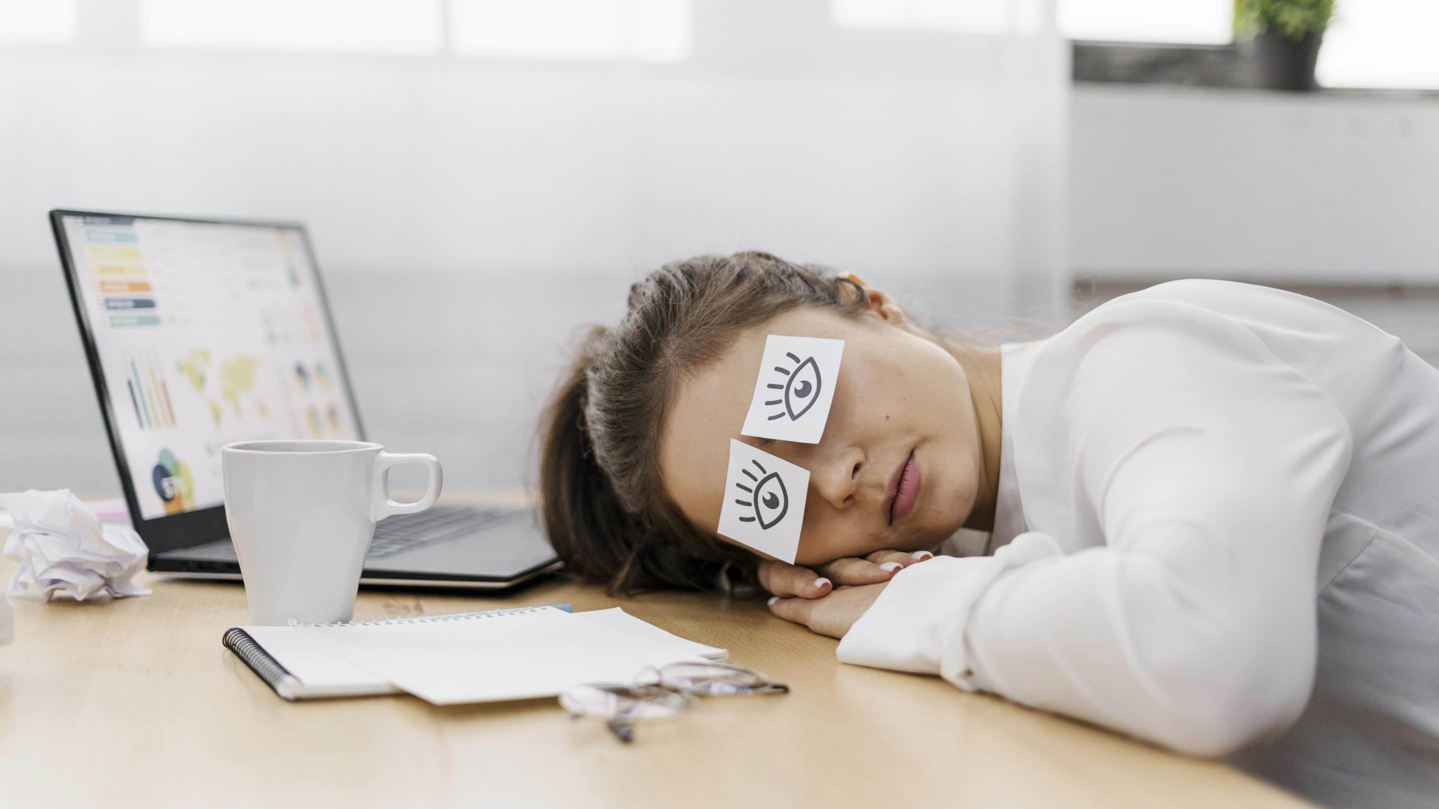 tired-businesswoman-covering-her-eyes-with-drawn-eyes-on-paper